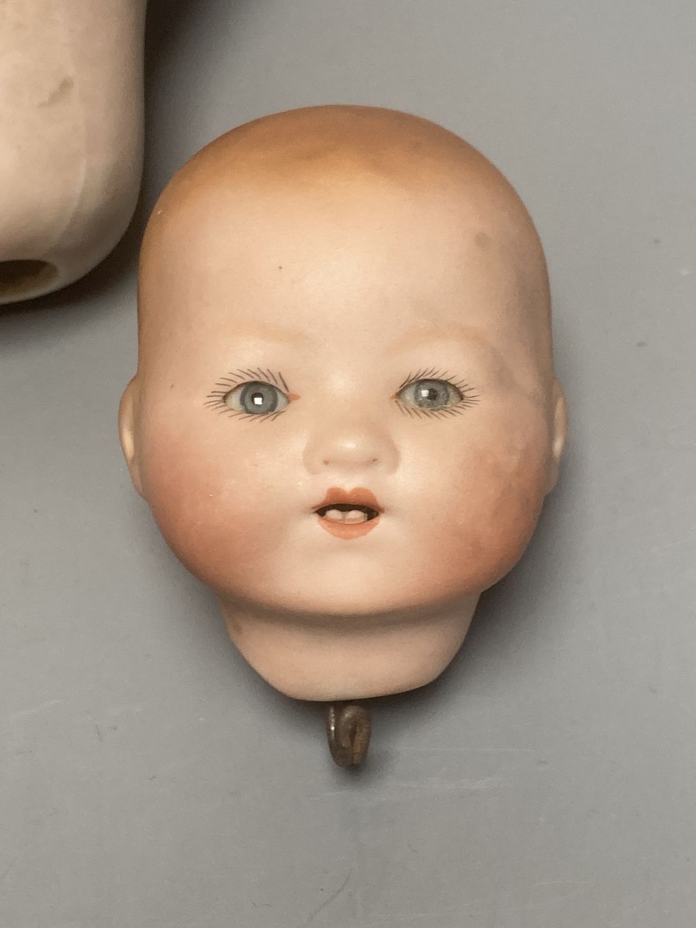 A Kammer & Reinhardt / Simon & Halbig bisque doll head, 10cm, three other German bisque doll heads and two English bisque doll heads,